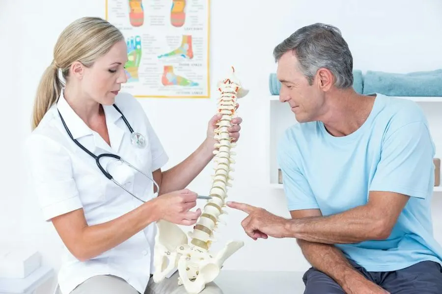 Physical therapist reviewing spine anatomy with a patient